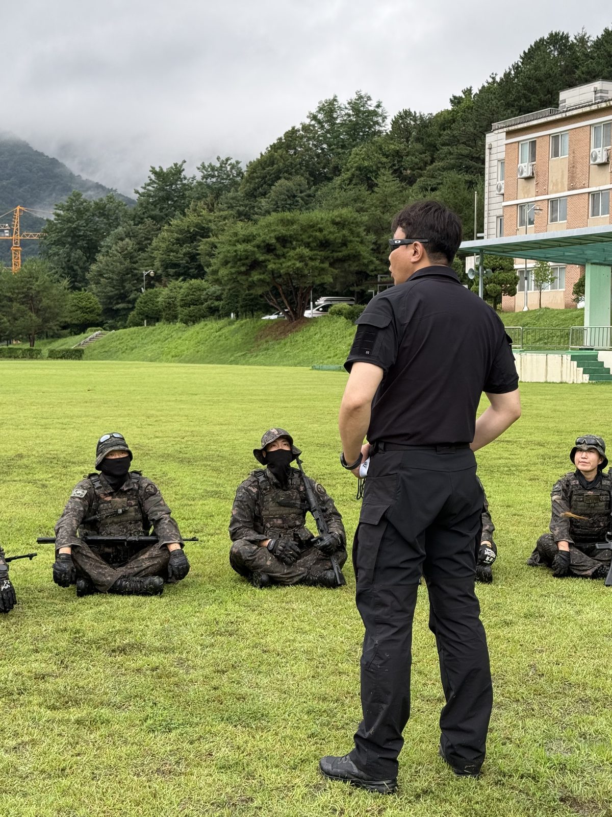 Instructor addressing armed special forces trainees in the field